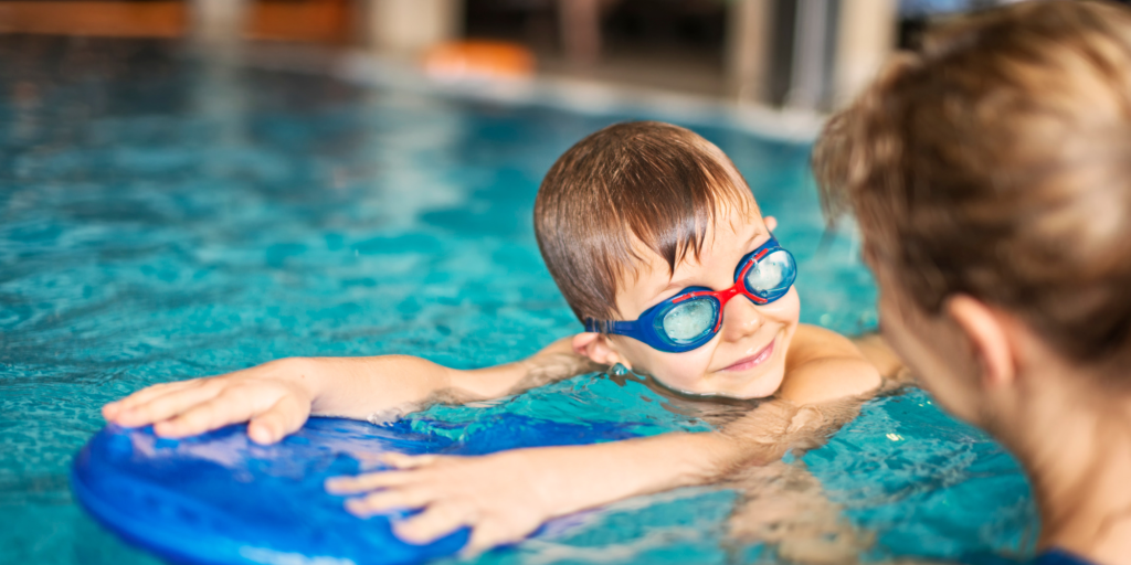 A swim teacher teaching a child